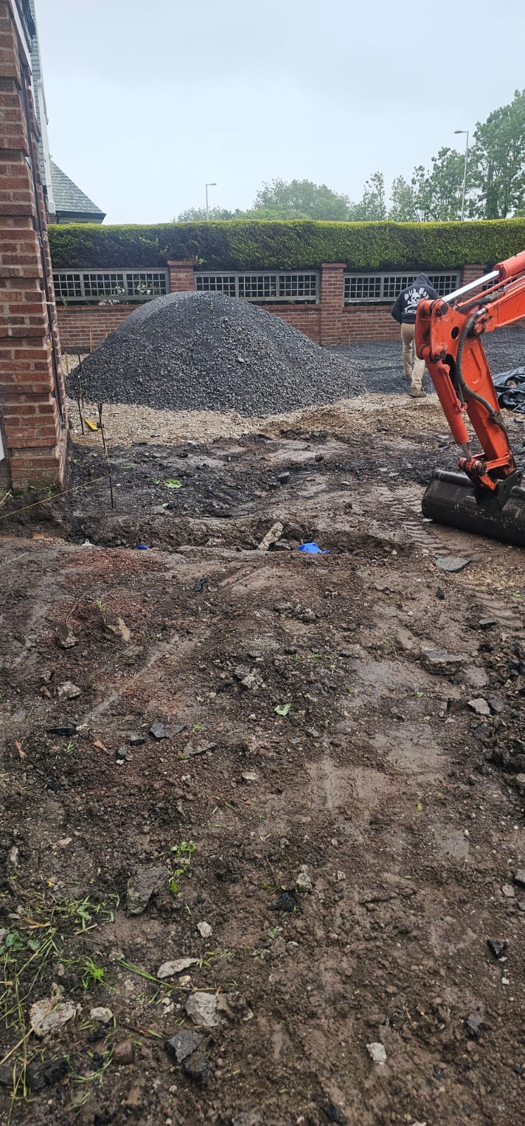 Excavated ground with stone subbase being tipped onto site
