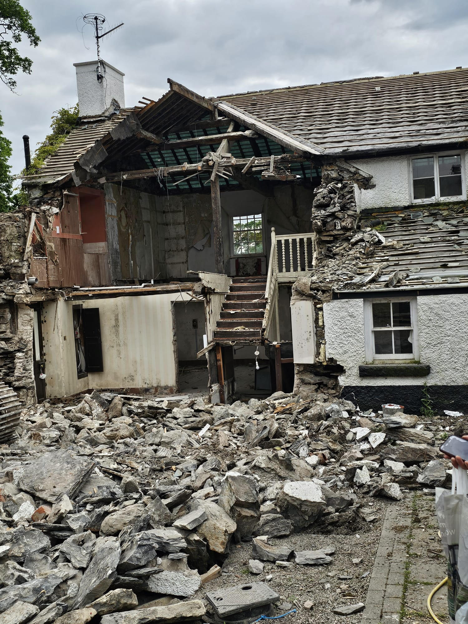 Partial demolition exposing original stone walls and roof timbers