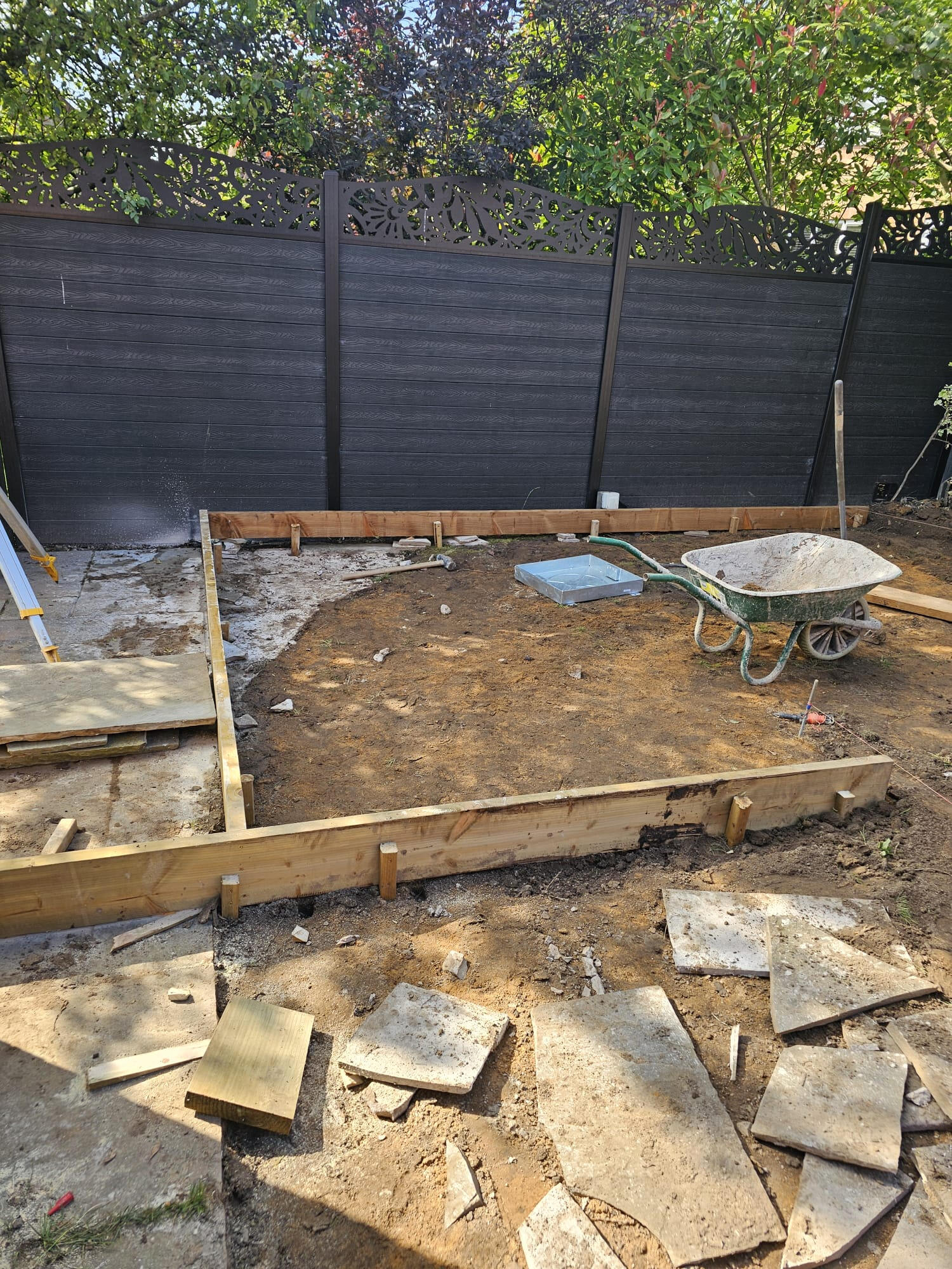Timber-shuttered lawn bay formed against the composite fence ready for sub-base