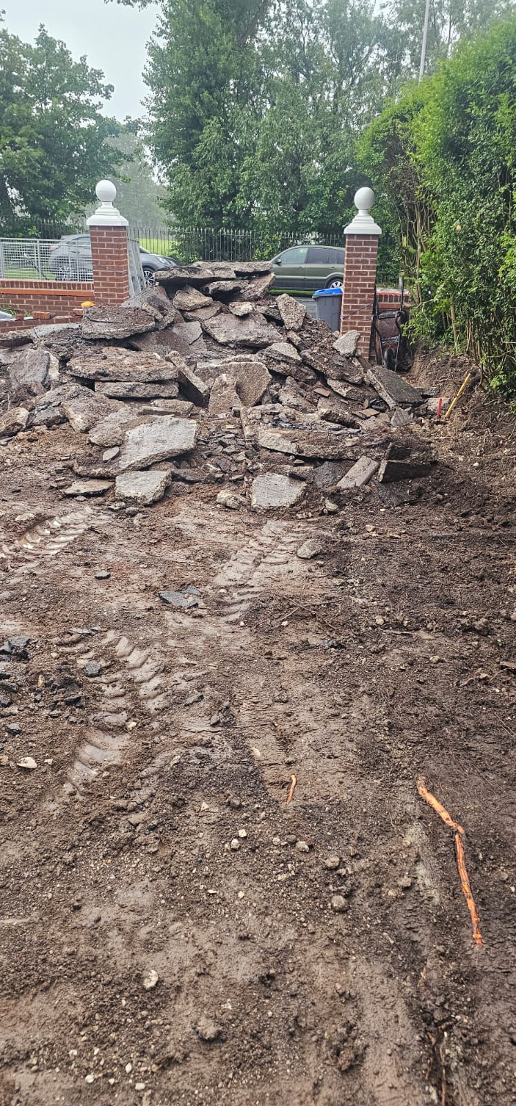 Pile of broken tarmac between brick gate pillars after dig-out