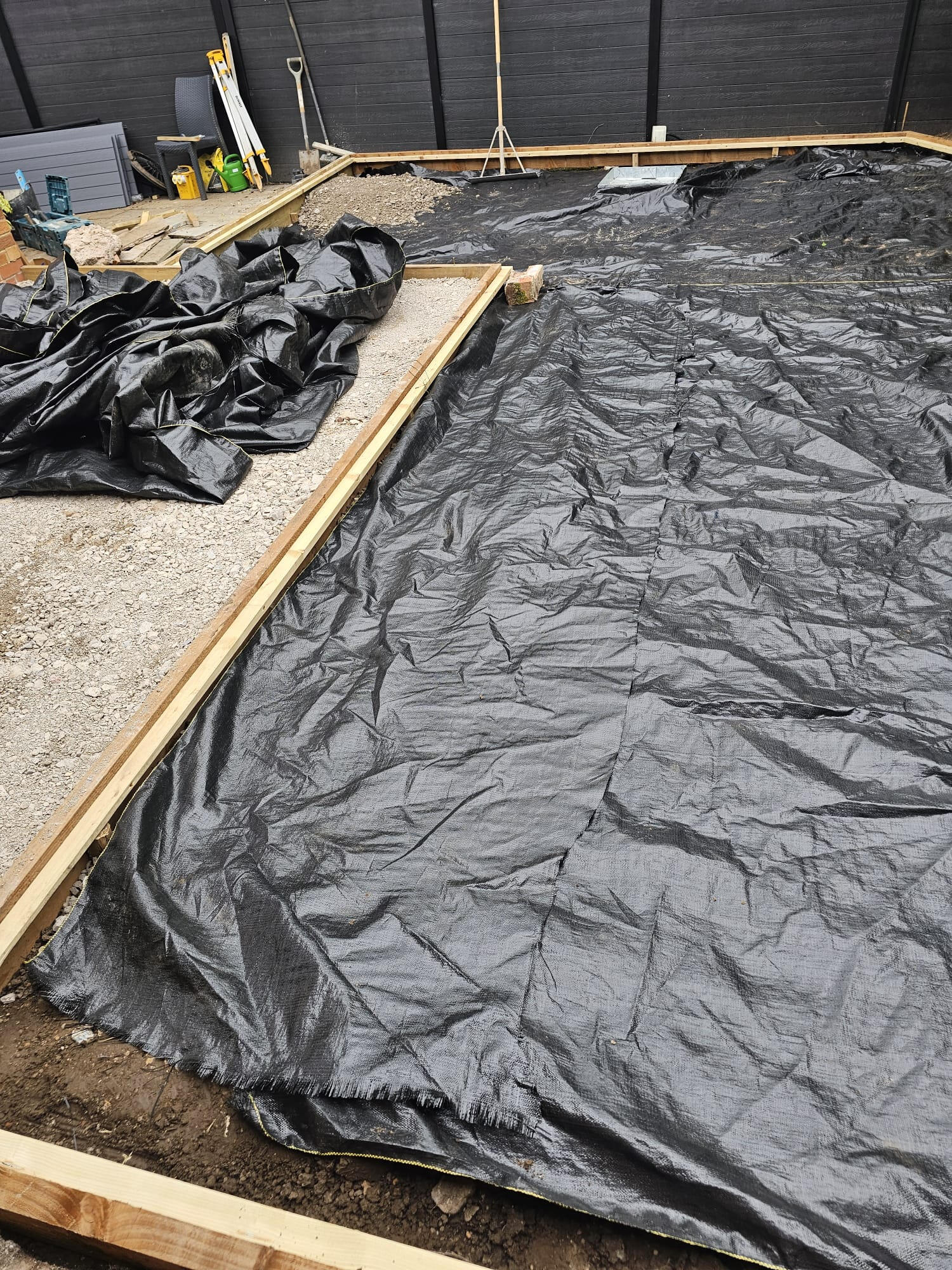 Weed-suppressant geotextile membrane laid over the prepared base inside the timber frame