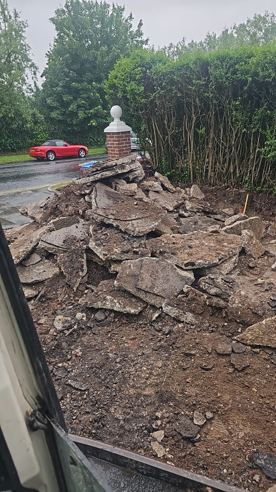 Old tarmac driveway broken out and stacked at the entrance