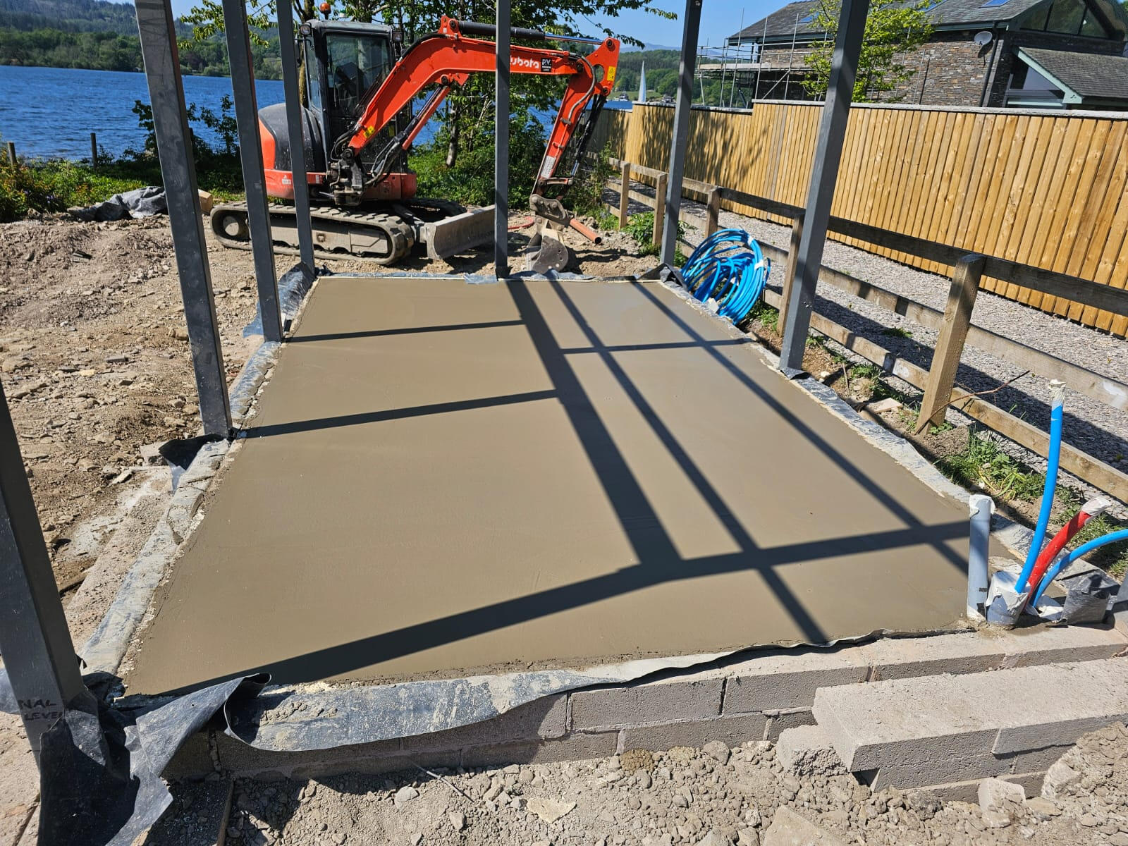 Finished concrete slab on a lakeside property with mini-excavator